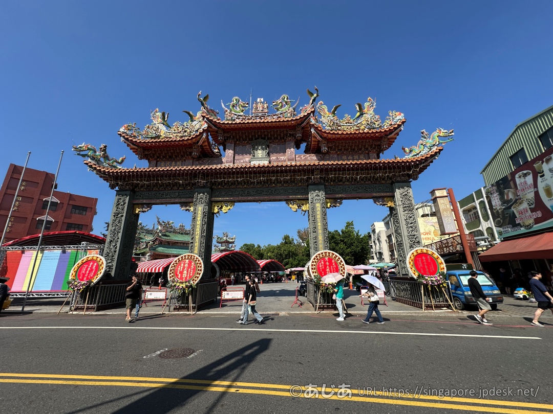 立派な装飾が施された安平の寺廟の門と、その前を歩く人々の様子