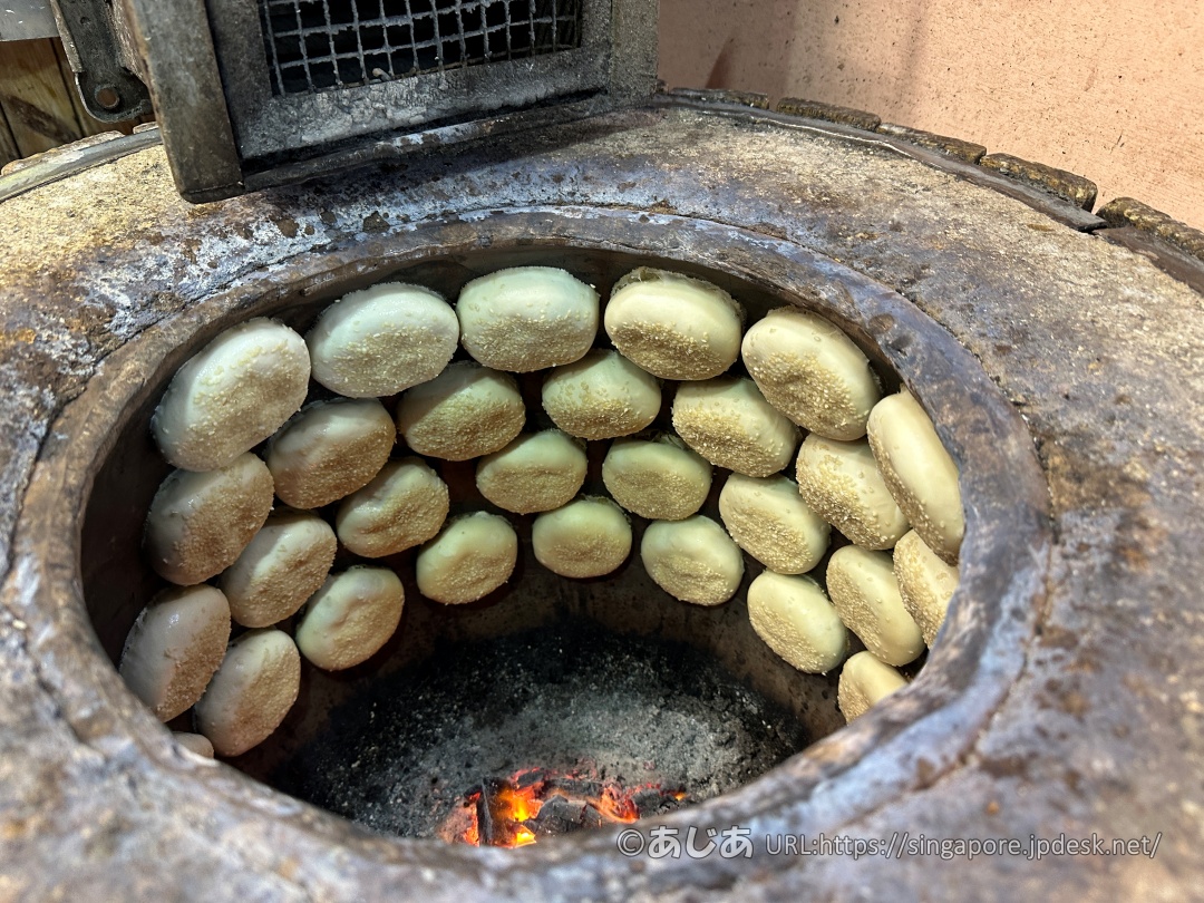 炭火窯の内部の壁面に沿って並べられ、焼かれているたくさんの胡椒餅