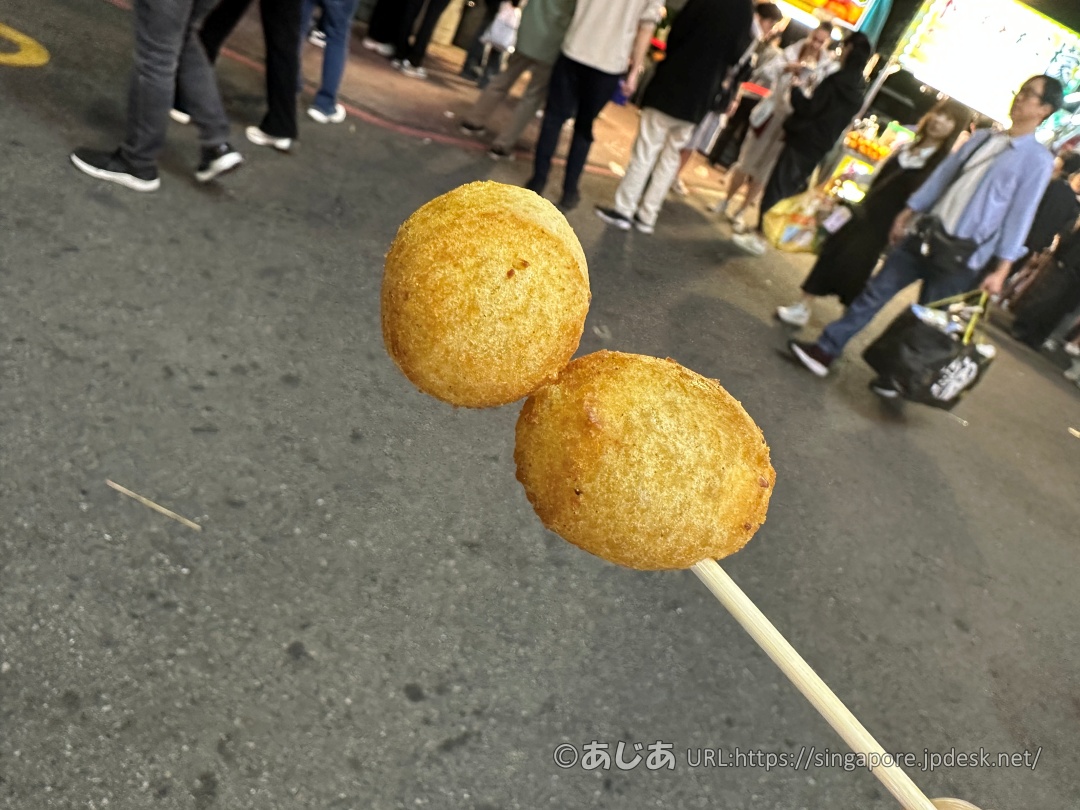 竹串に2つ刺さった、きつね色にこんがり揚がった丸い地瓜球