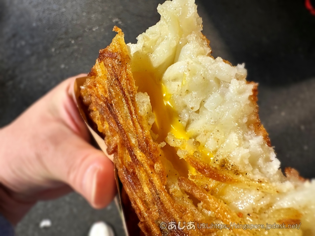 一口かじった薯の燒の断面。中からとろけた黄色いチーズが見える