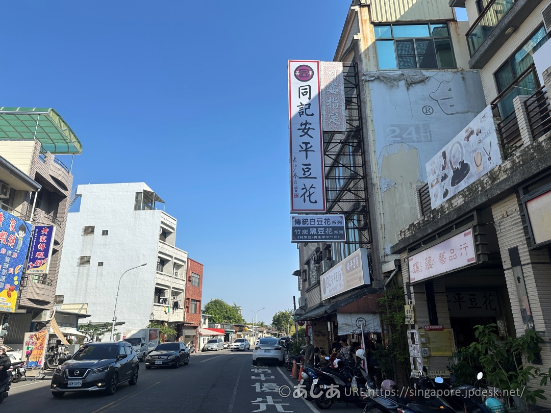 通りに掲げられた「同記安平豆花」の縦長の大きな看板とお店の外観