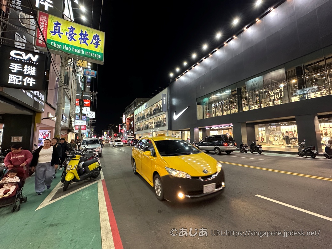 逢甲夜市周辺の夜の大通りを走る黄色いタクシーとナイキの店舗