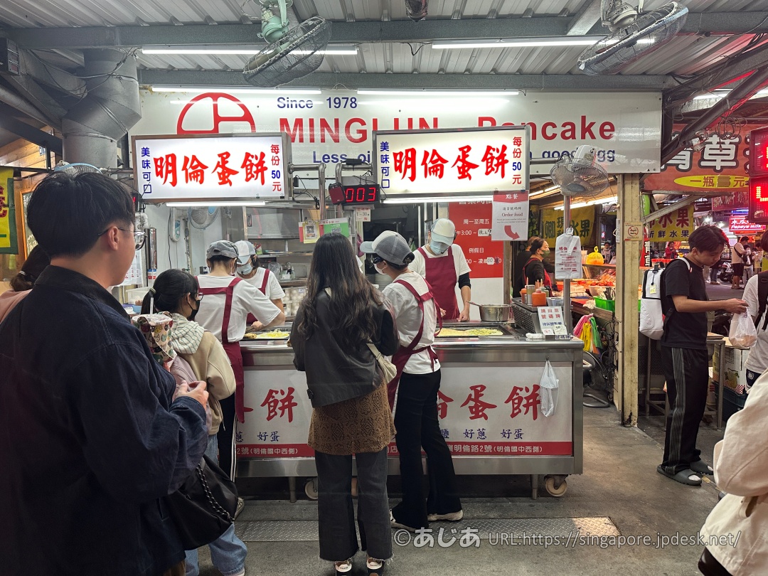 明倫蛋餅の屋台の前に並ぶお客さんと調理するスタッフ