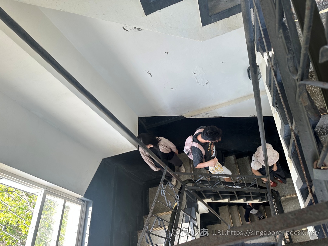 展望台の内部。白と黒の壁面と、階段を降りる人々の様子