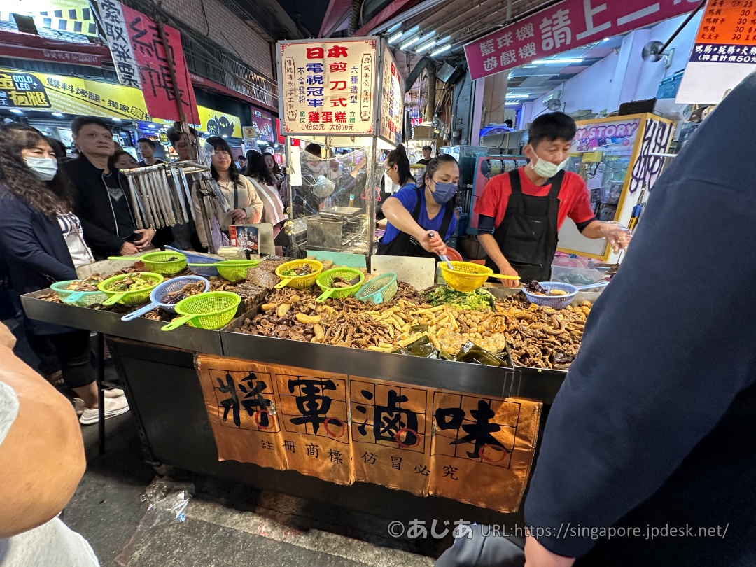 將軍滷味の屋台。山積みにされた様々な種類の滷味(台湾風煮込み)の具材と、注文を受ける店員、並ぶお客さんの様子