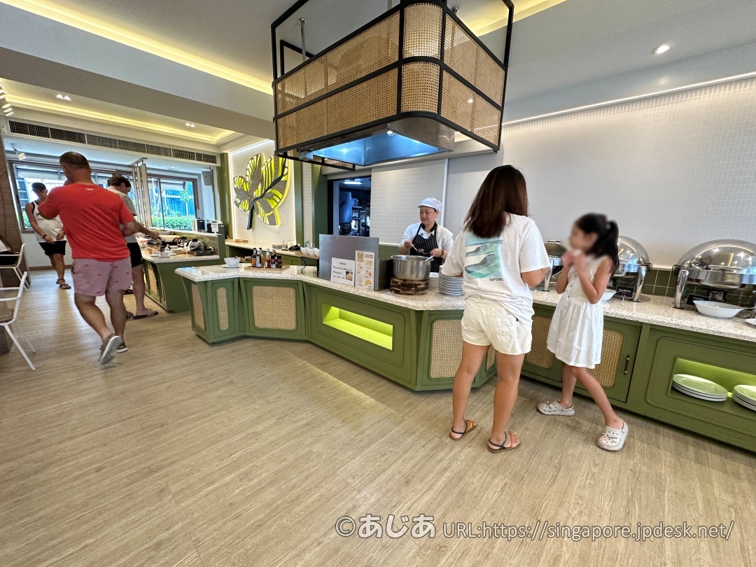 グリーンのカウンターに保温用の丸い容器（チェーフィングディッシュ）が並ぶ朝食ビュッフェコーナー。