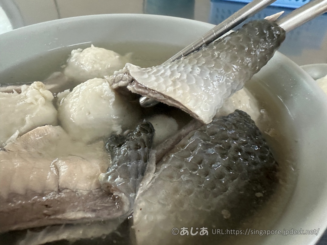 お箸で持ち上げられた、分厚い身がついたサバヒーの魚皮のアップ