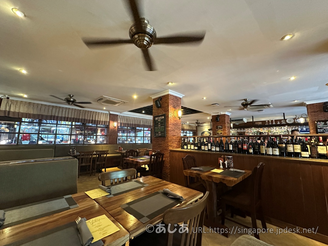 ビーフィーターの店内。木製のテーブル席が並び、仕切り棚にはワインボトルがずらりと並べられている。