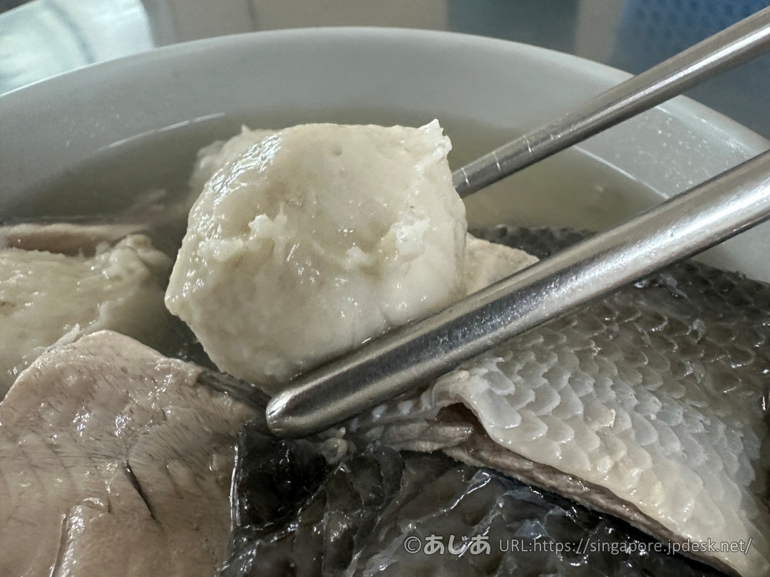 お箸で持ち上げられた、大きくて白いつみれ（魚丸）のアップ