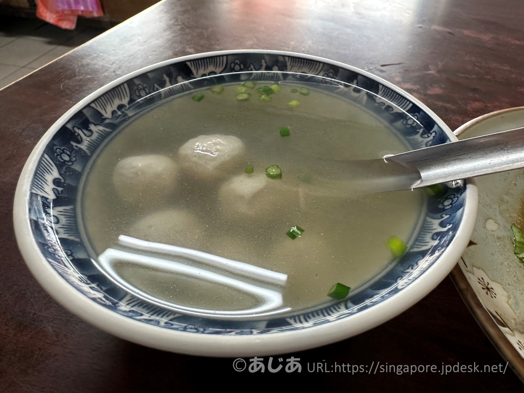 青い模様の入ったどんぶりに入った、澄んだスープと複数の白い魚のつみれ（魚丸湯）