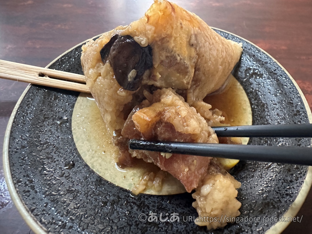 お箸で割った肉粽の断面から、大きくて脂の乗った豚肉の塊が見える様子