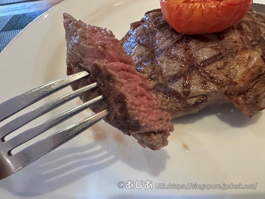 フォークとナイフでカットされたステーキの断面。美しいピンク色のミディアムレアに焼き上がっている。