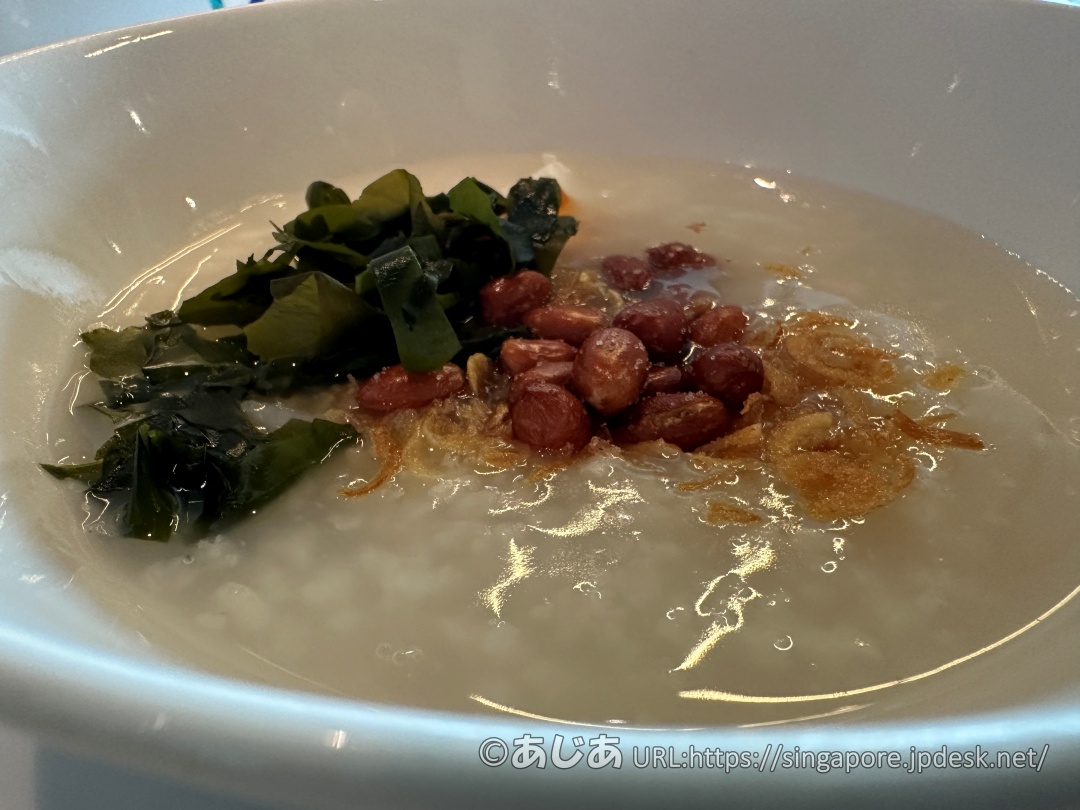 ワカメやピーナッツ、フライドオニオンがトッピングされた美味しそうなおかゆのアップ