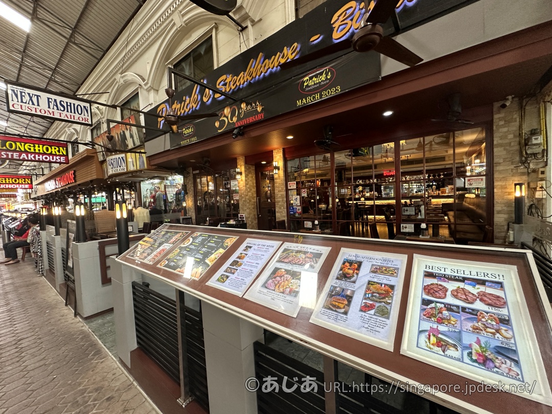 アーケード街にあるパトリックスの店舗外観。「30 years ANNIVERSARY」の文字が掲げられ、店頭にはメニューが並んでいる。