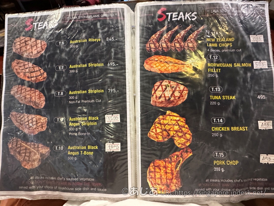 メニューのステーキページ。様々な部位のステーキ肉の網目状の焼き目がついた写真と価格（バーツ）が並んでいる。