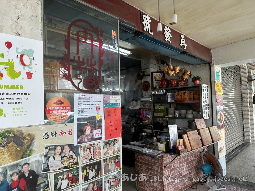 再發號百年肉粽の入り口横の壁。お店のロゴや、たくさんの写真付きの記事が貼られている