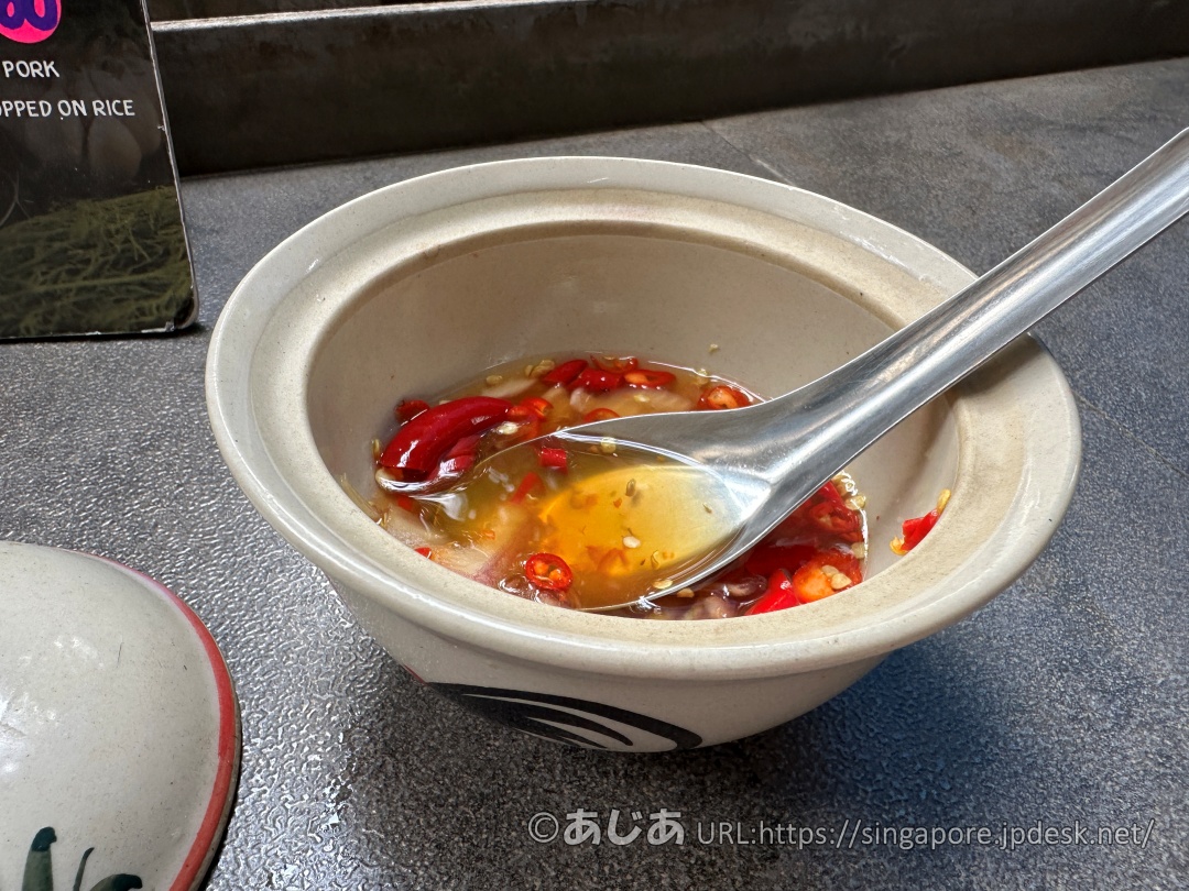 小さな陶器の壺に入った調味料。ナンプラー(魚醤)の中に、刻んだ赤唐辛子やニンニクがたっぷり漬け込まれている。