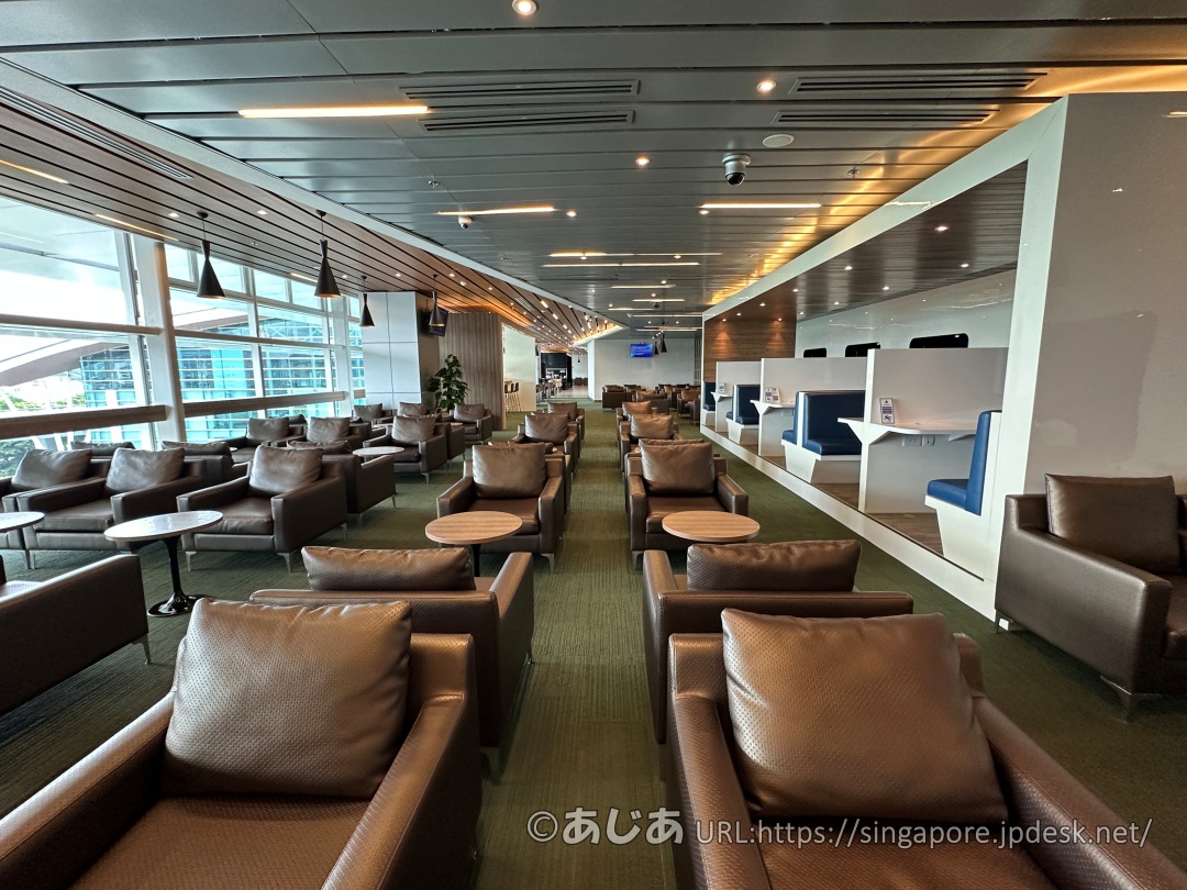 CIP Orchid Loungeの全体写真。窓際の景色と並んだ革張りソファ