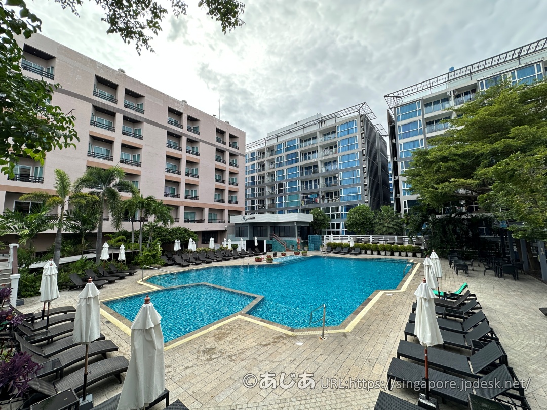 アレカロッジの長方形の大きなメインプール。周囲にサマーベッドとパラソルが並んでいる。