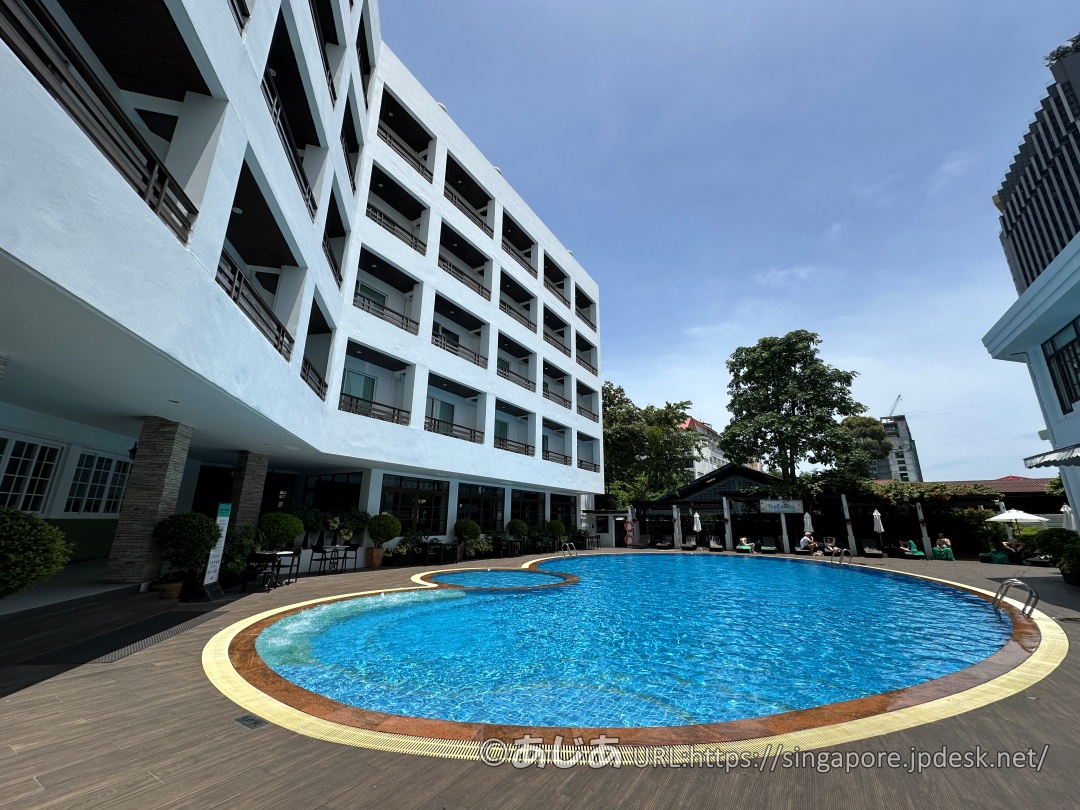 アレカロッジの長方形の大きなメインプール。周囲にサマーベッドとパラソルが並んでいる。