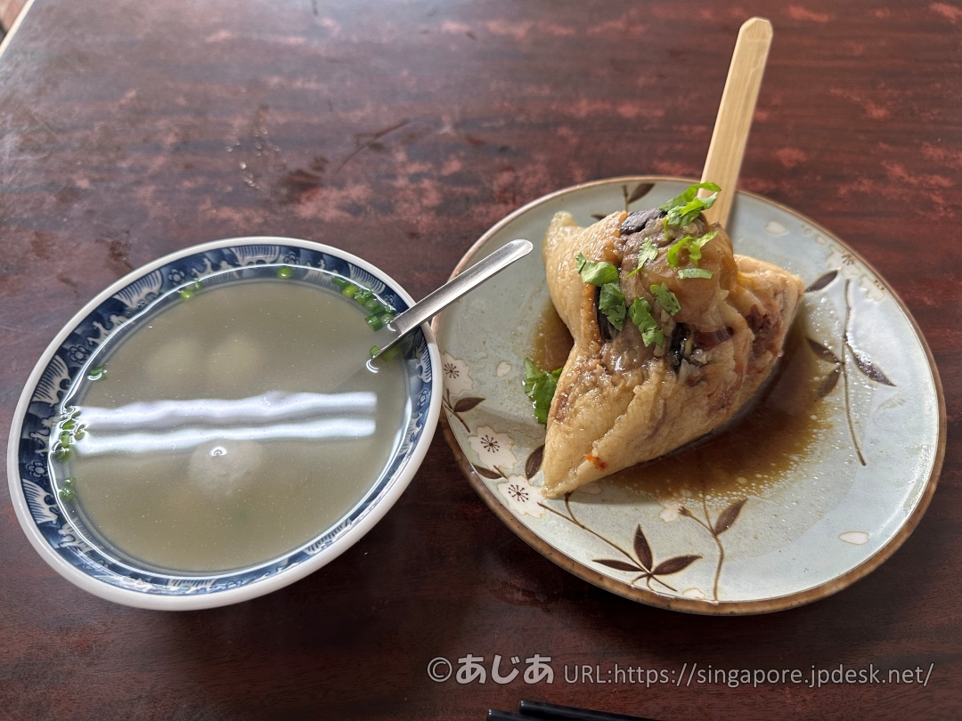 テーブルに置かれた特製八寶肉粽と、つみれが入った透明なスープ（魚丸湯）のセット