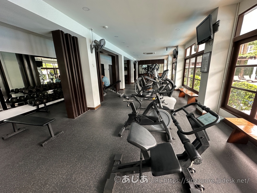 アレカロッジのフィットネスジム内観。エアロバイクやダンベルなどのトレーニング機器が並んでいる。