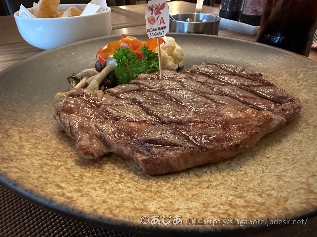 リブアイステーキのアップ写真。網目状の焼き目が美しく、肉汁で表面がツヤツヤと光っている。