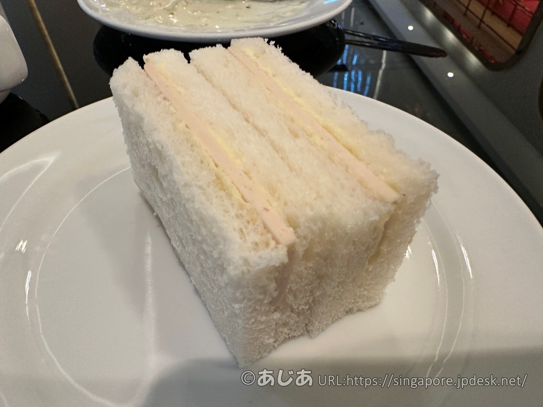 お皿に乗った四角いハムチーズサンドイッチのアップ写真。