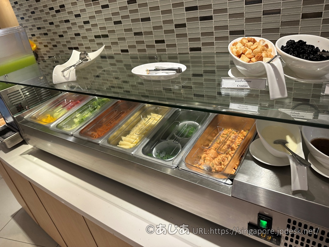 保冷ケースに並んだカット野菜と、その横にあるクルトンなどのトッピング類。