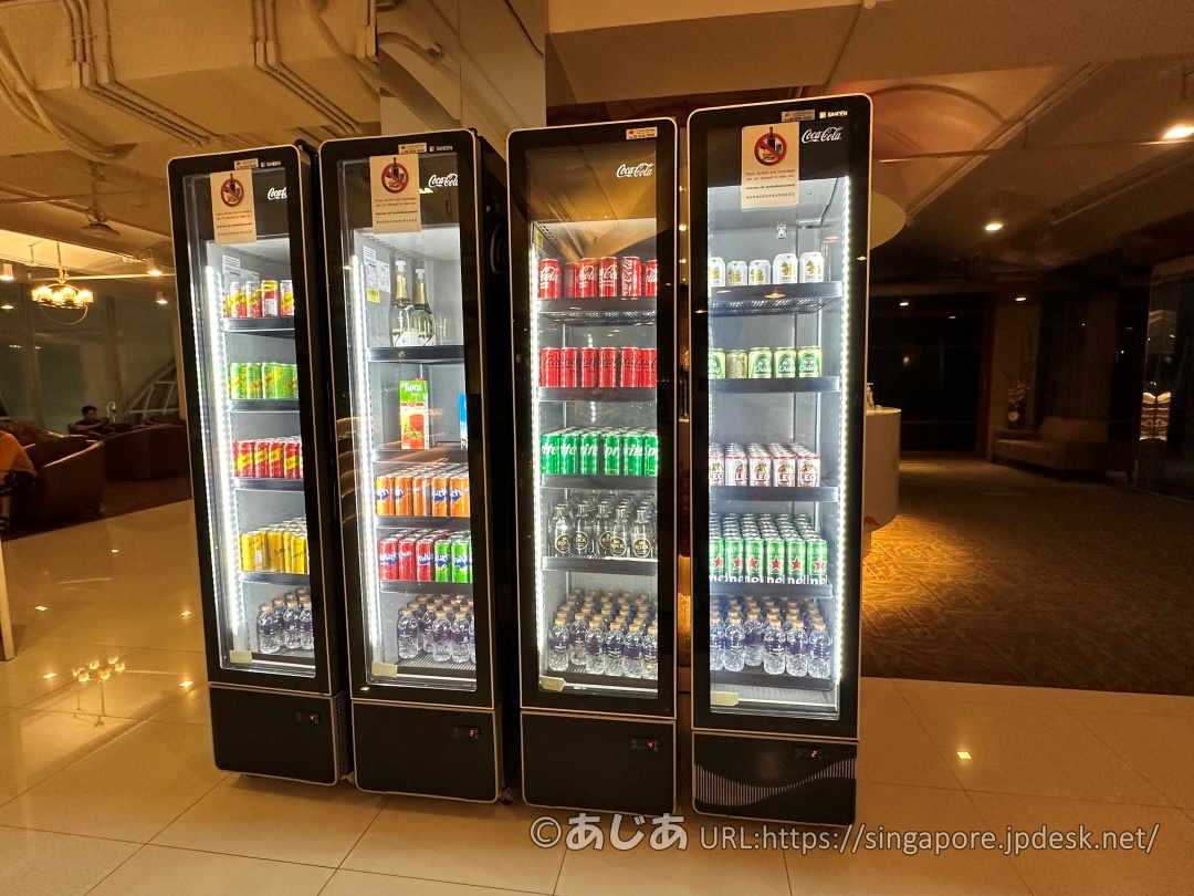 ラウンジ内に並んだ4台のガラス扉付き冷蔵庫。ソフトドリンクの缶やペットボトルが隙間なく並んでいる。