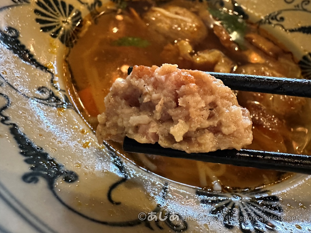 お箸で半分に割られた肉団子の断面アップ。粗挽き肉のジューシーな様子が伝わる。