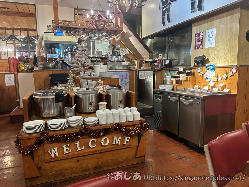 HAN'Sの店内にあるセルフエリア。大きな炊飯器やスープポットが並んでおり、「WELCOME」と書かれた木製の台がある。