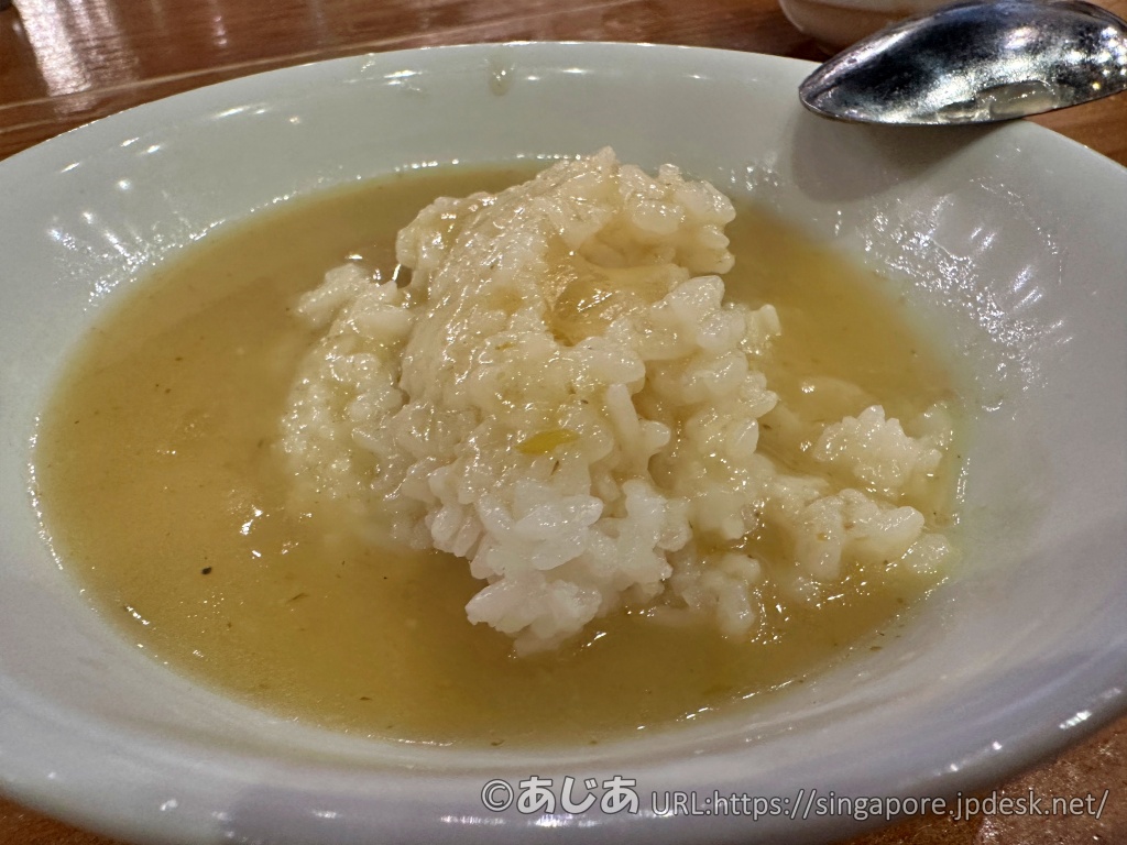 白いお皿に盛られたライスに、サラサラとしたタイグリーンカレーがかけられている様子。