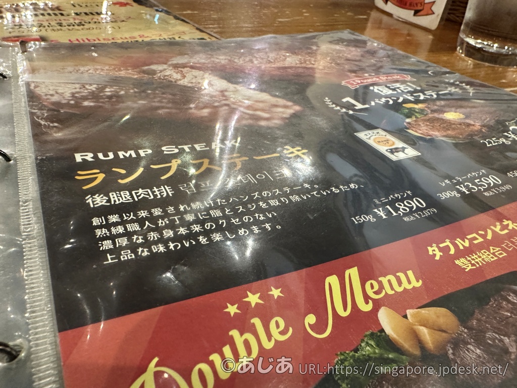 メニュー表のランプステーキ部分のアップ。「創業以来愛され続けたハンズのステーキ」という説明書きと、150g、300g、450gなどの価格が書かれている。