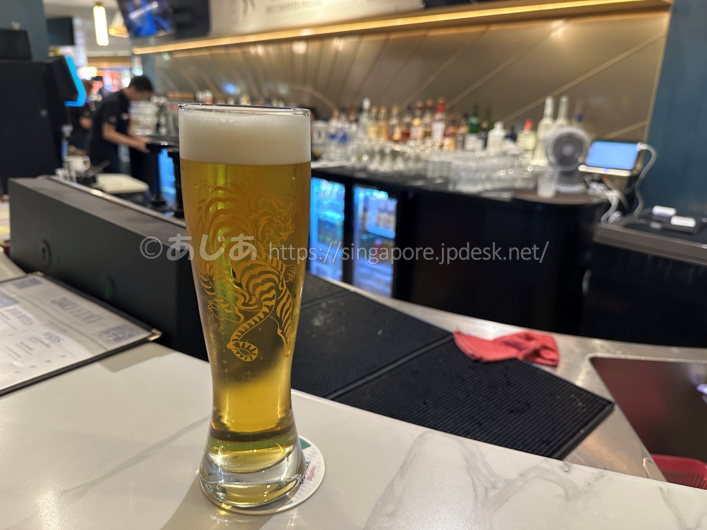 バーのカウンターに置かれたトラのロゴ入りビールグラス