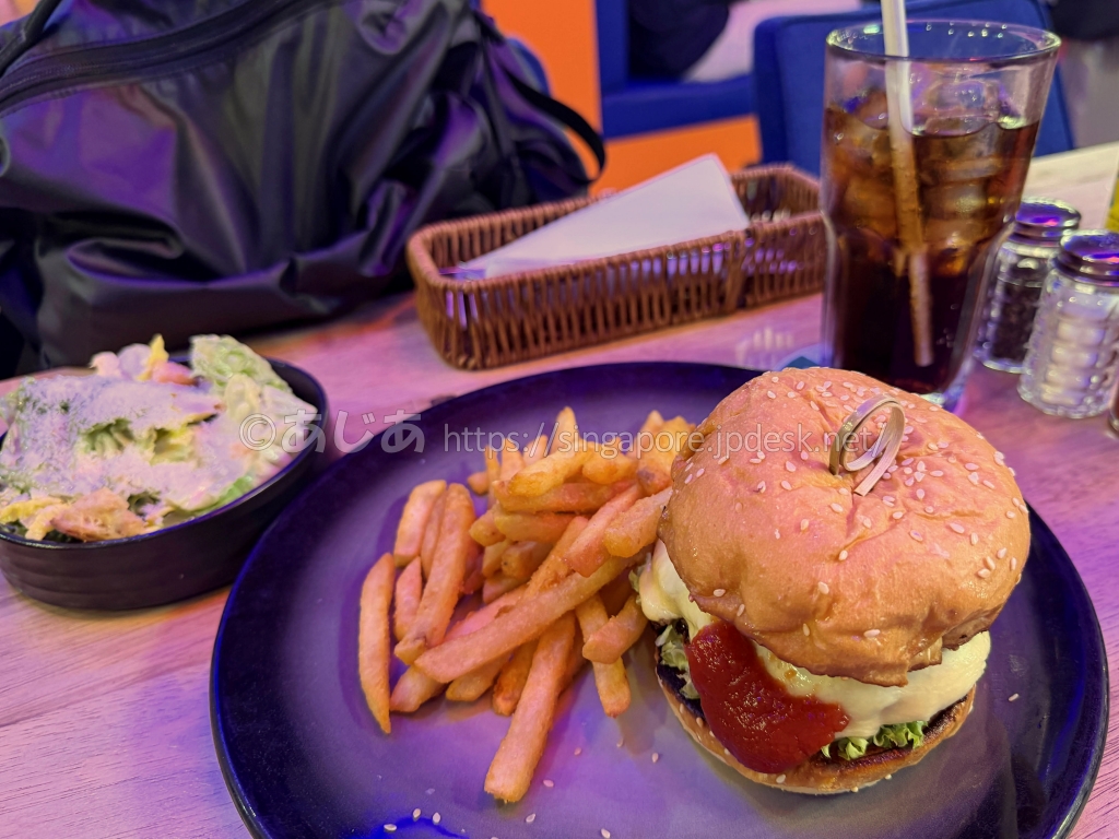 ハンバーガーとフライドポテト、サラダ、ドリンクを並べたテーブル