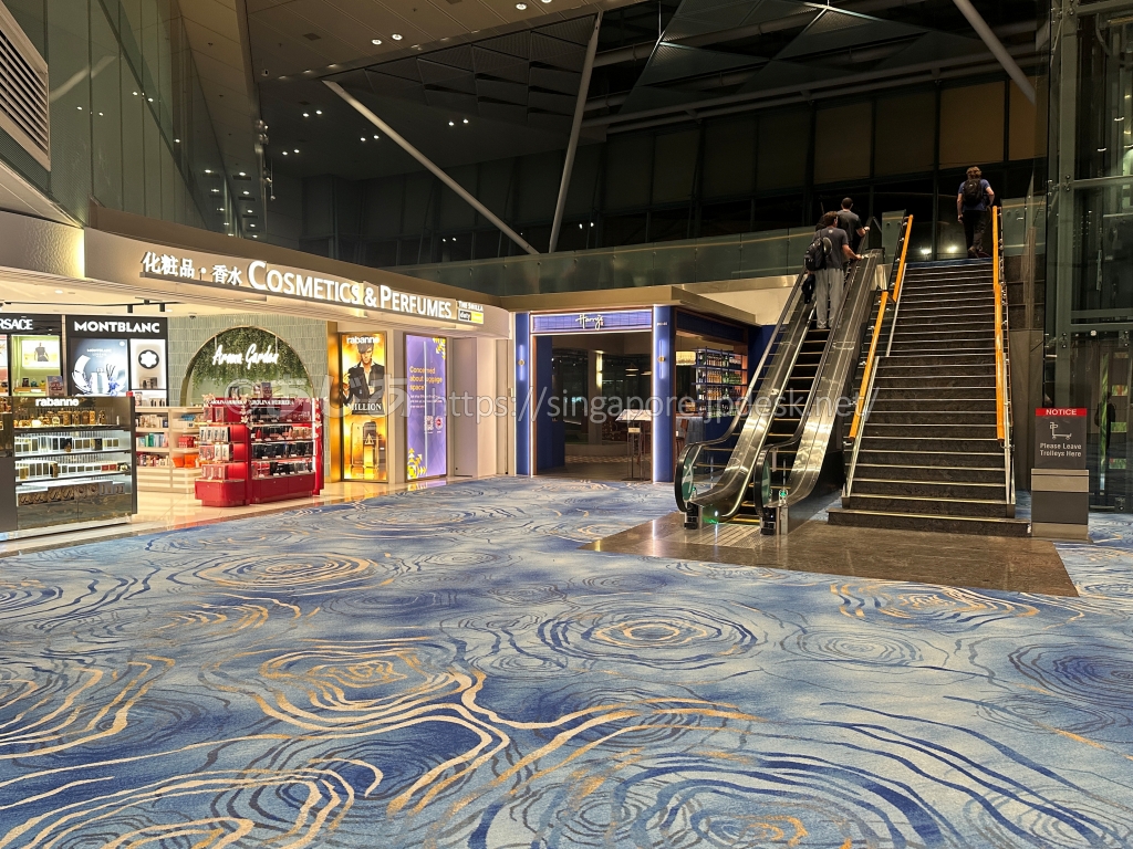 空港通路のエスカレーター横にある青い店舗入口