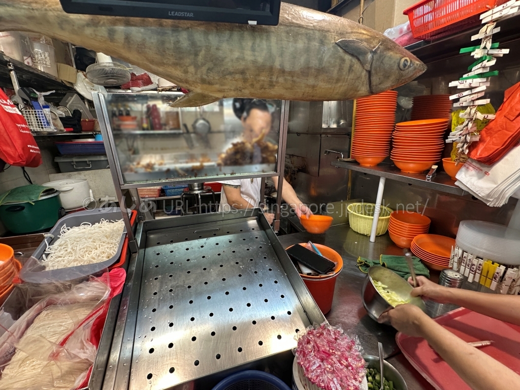 大きな魚を掲げたSong Kee Teochew Fish Porridgeの調理場