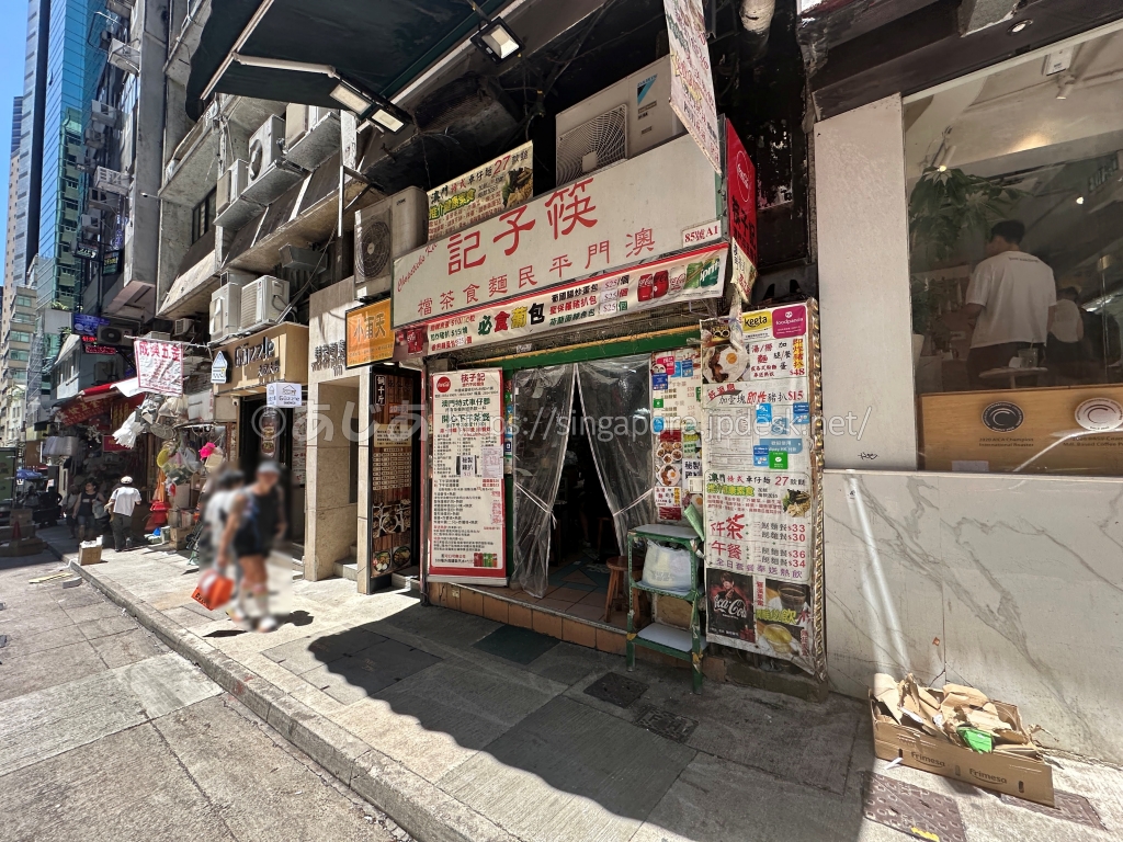沾仔記の近くにある白地に赤文字の筷子記の外観