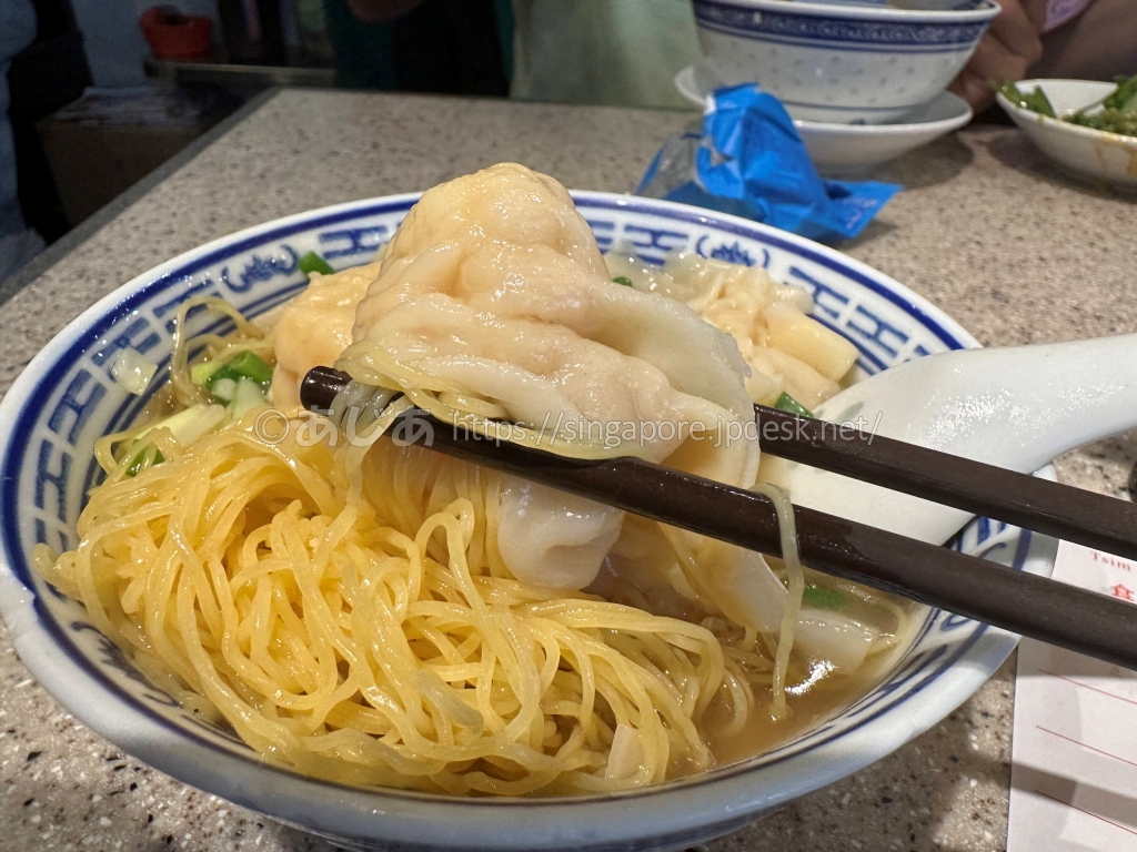 箸で持ち上げた沾仔記の大粒海老ワンタンと極細の香港麺