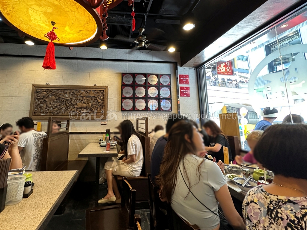 ランチ客で混雑する香港中環の沾仔記店内とミシュランの掲示