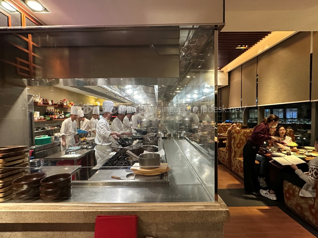 沙田18のガラス張りオープンキッチンで調理する大勢の料理人