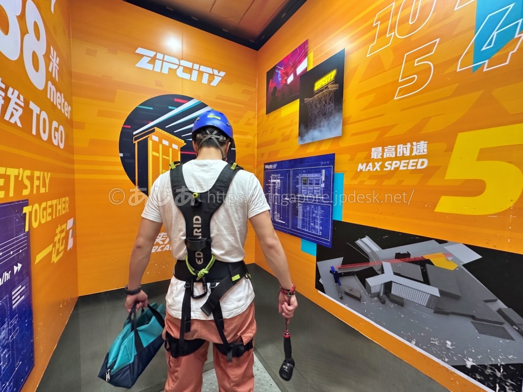 ヘルメット、ハーネス、手荷物バッグ、レンタルカメラを装着したZIPCITY参加者