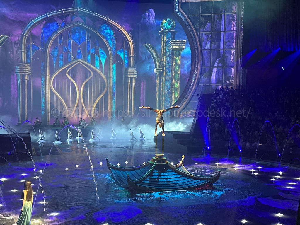 水上の小舟で片手倒立を披露する演者