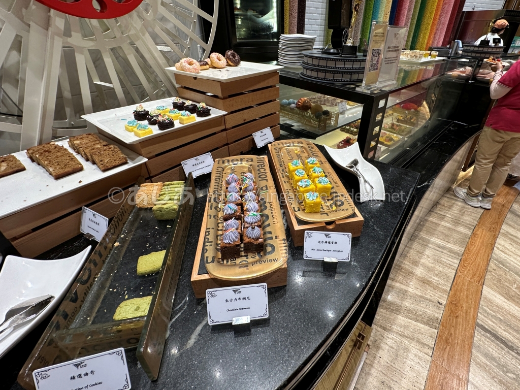 スポットライトのケーキ、ブラウニー、ドーナツが並ぶデザートコーナー