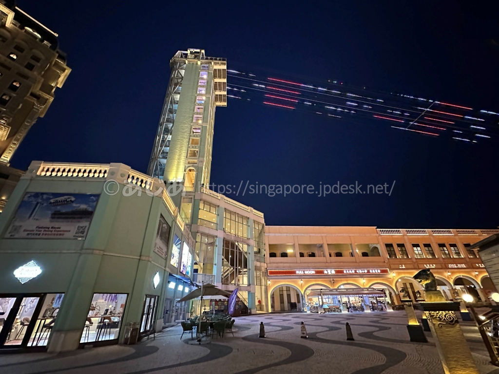 夜のリスボエタ・マカオと上空を走るZIPCITYの光るワイヤー