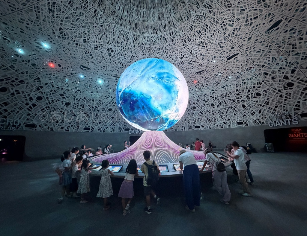 Exploriaの中央にある巨大球体Biopoolとパネルのクイズで遊ぶ子どもたち